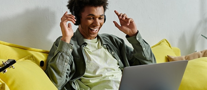 Female student wearing headphones while online with Spectrum Internet. 