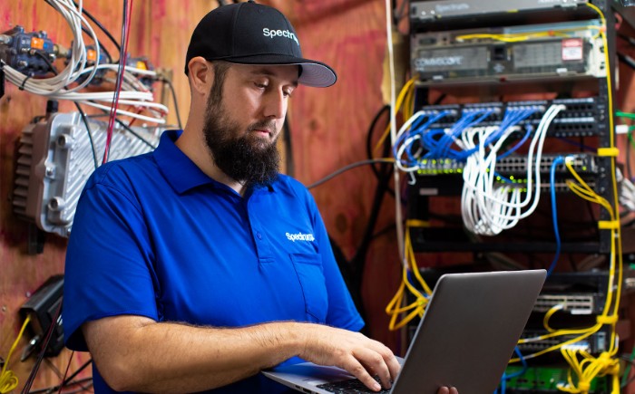 Un representante de servicio técnico de Spectrum usando una laptop