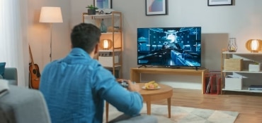 Person gaming on big screen TV