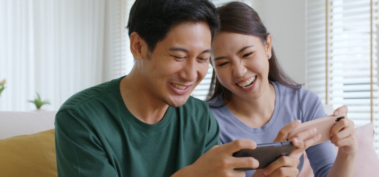 Two Spectrum Mobile customers looking at a mobile phone.